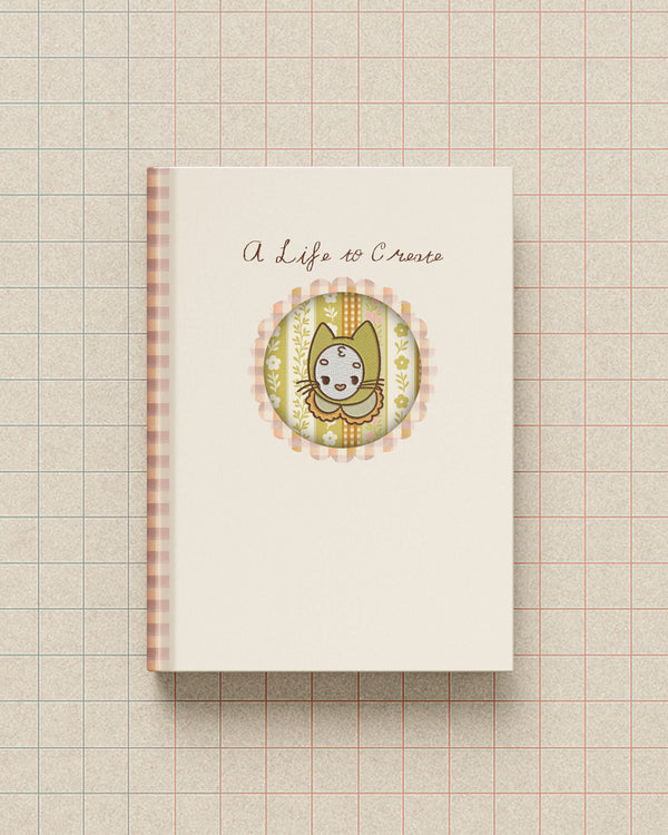 Notebook with a decorative cover featuring Mamoo the cat and text on a grid background