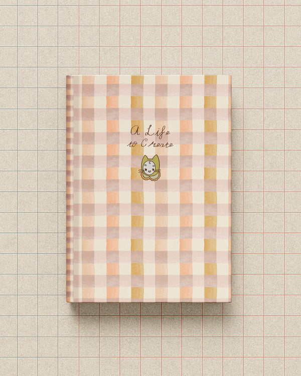 A Life to Create journal with a coral gingham cover and minimal illustration of Mamoo the cat